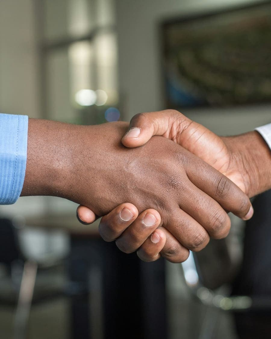 Two delegates shaking hands across a meeting table