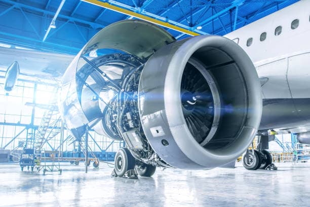 An airliner's engine open for inspection in a maintenance hangar