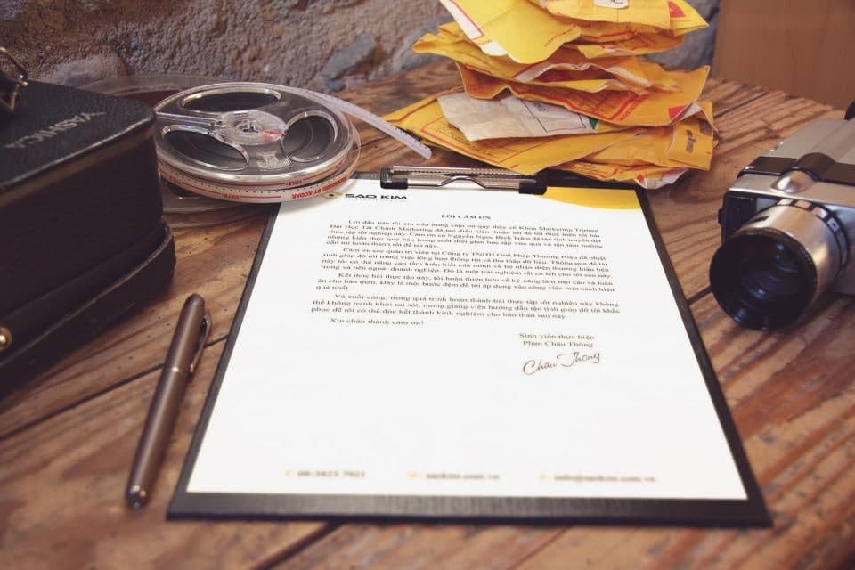 A signed formal letter on a desk beside sealed correspondence