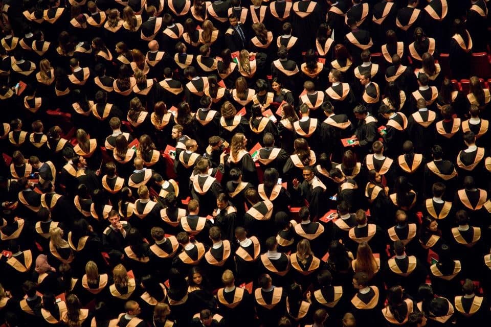 A hall of graduates in academic dress, photographed from above